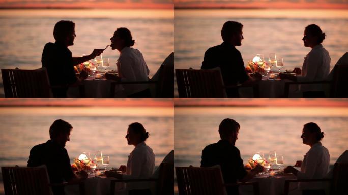 日落时分在海滩上用餐的情侣