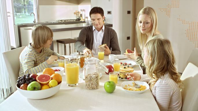 一家人在摆好的桌子上吃早餐