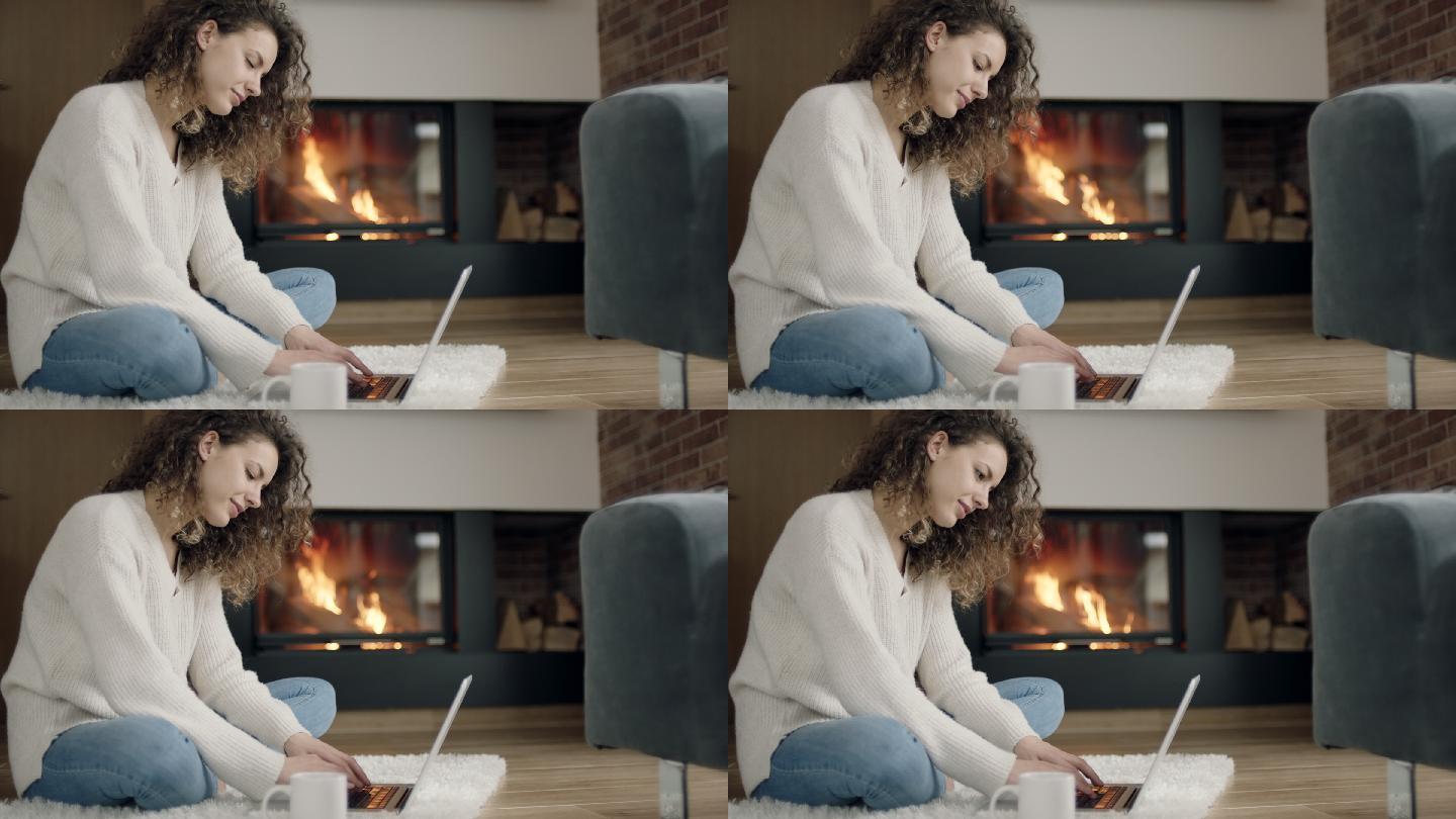 坐在壁炉前使用笔记本电脑的女人