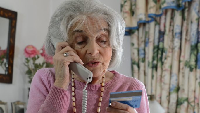 在电话中提供信用卡详细信息的老年妇女