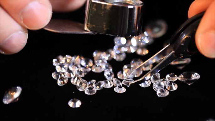 用放大镜检查一堆钻石的特写镜头。