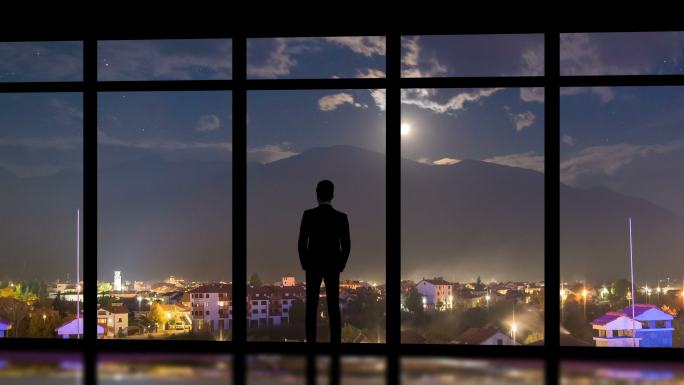 站在夜市背景全景窗附近的男子