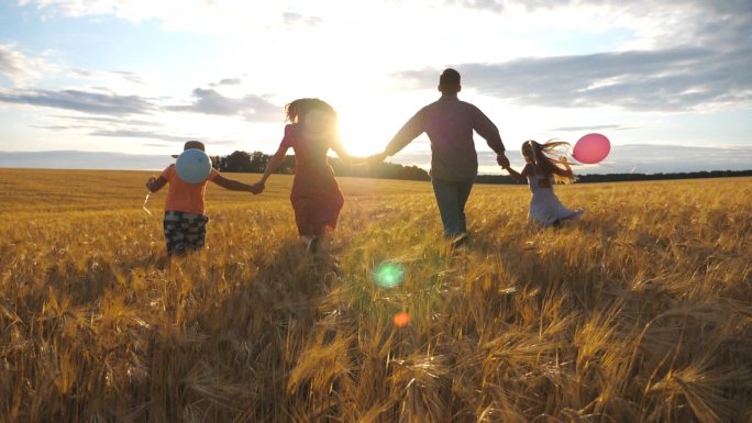 幸福的一家人在大麦草地上慢跑