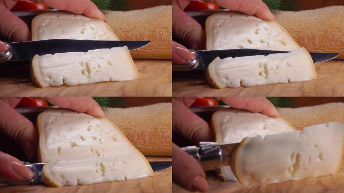 刀子切下一块柔软的羊奶酪