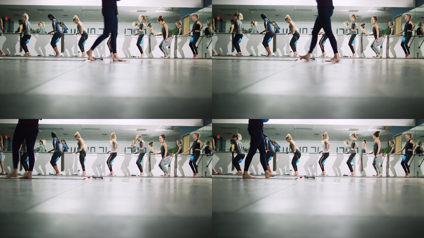 一群女性踮着脚尖站在健身室练芭蕾舞