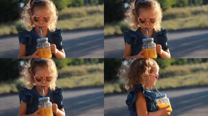 夏日，戴墨镜的小女孩在夕阳下喝着果汁