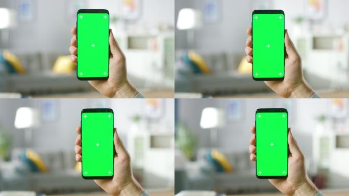 男子手持带有绿色模拟屏幕的现代智能手机