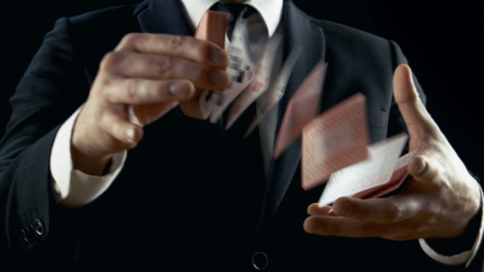 一魔术师表演纸牌戏法。