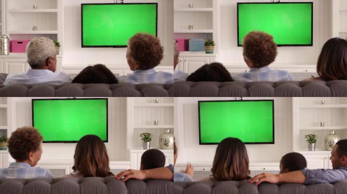 观看绿色屏幕电视拍摄的家庭后视图