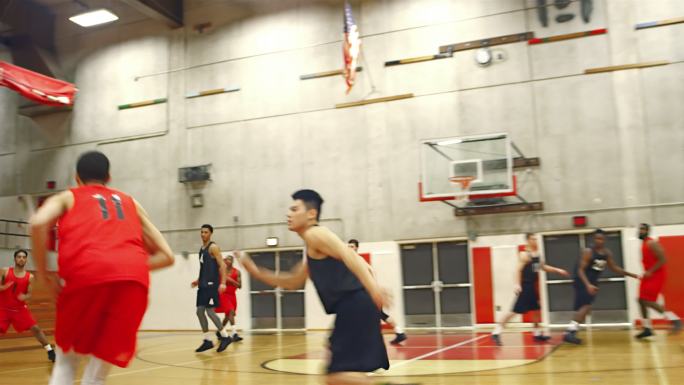 篮球运动员在比赛中将球传下球场并扣篮