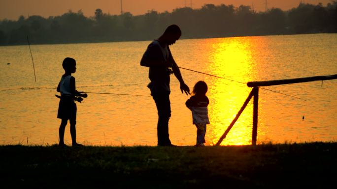 父亲和孩子在日落时钓鱼