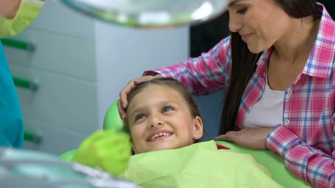 儿科牙医在手术前抚慰孩子。