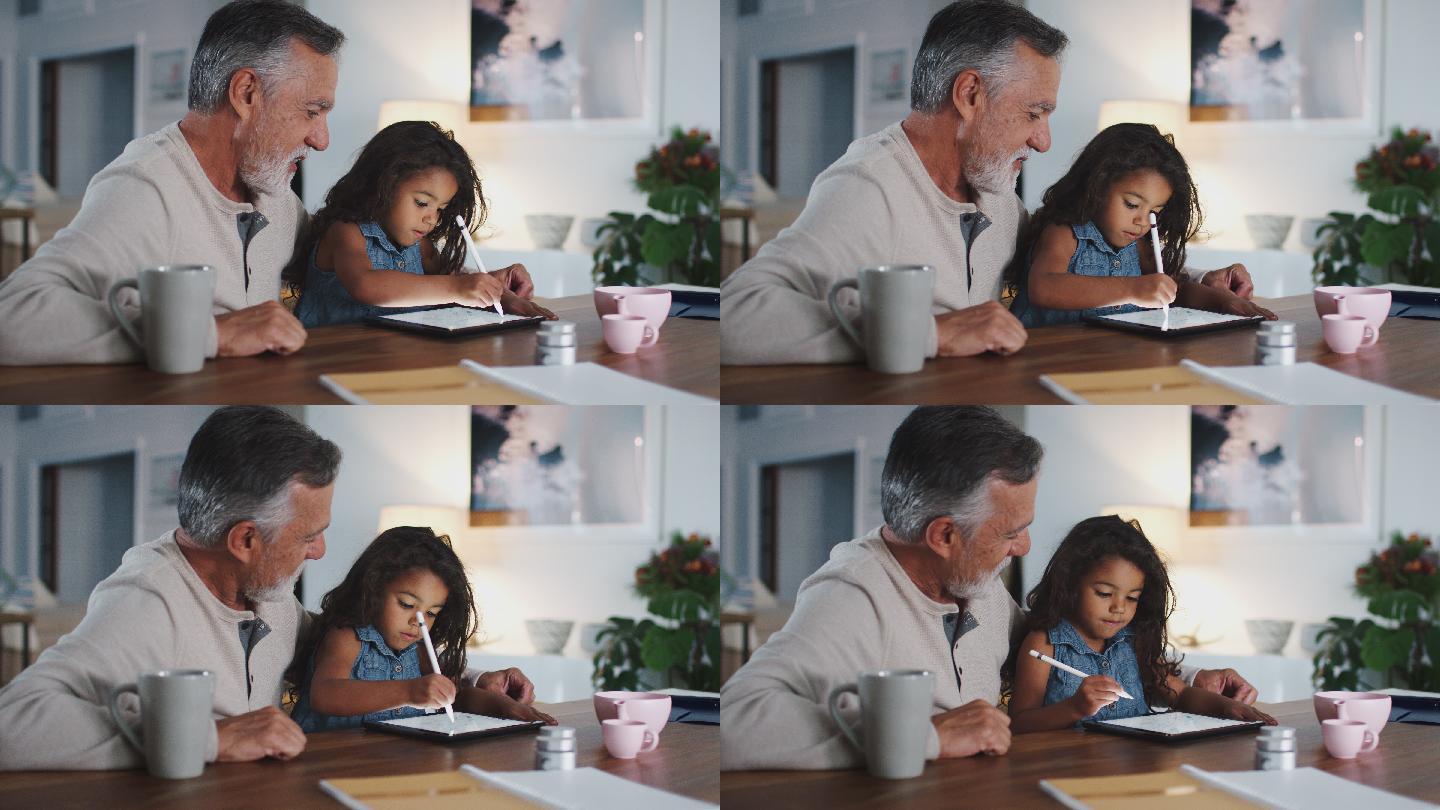 爷爷正在教导孙女使用平板电脑学习