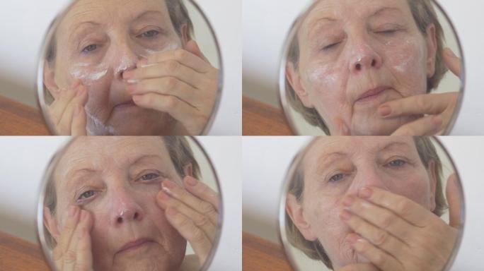 老妇人把面霜涂在脸上