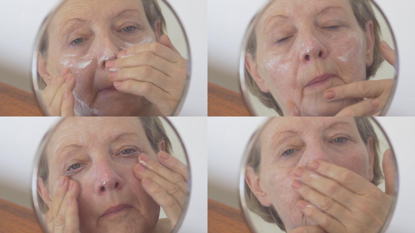 老妇人把面霜涂在脸上