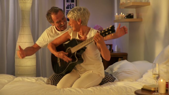 在床上弹吉他的老夫妇