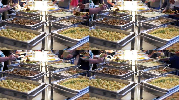 人们在自助餐桌挑选食物