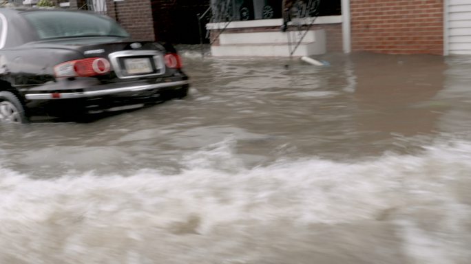 一辆汽车在被洪水淹没的街道上行驶
