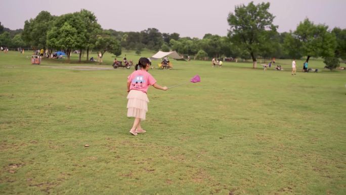 公园里扑蜻蜓小女孩
