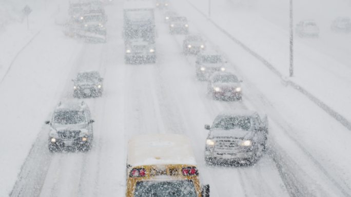 在冬季暴风雪中行驶的一排车辆