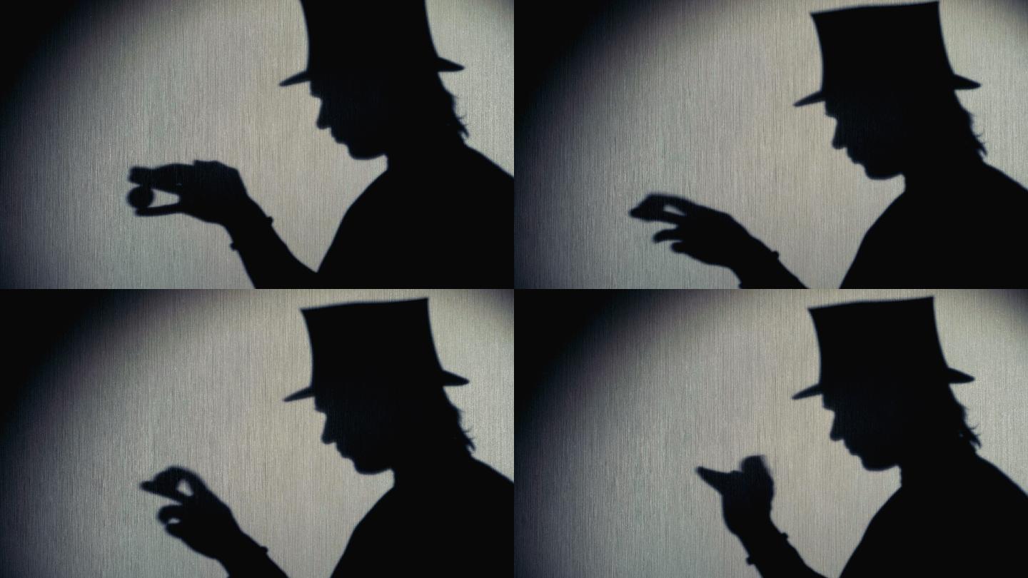 魔术师戴着礼帽表演魔术的剪影。