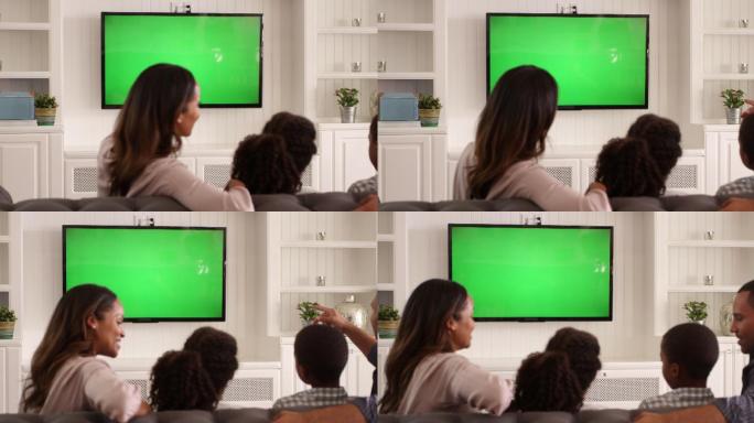观看绿色屏幕电视拍摄的家庭后视图