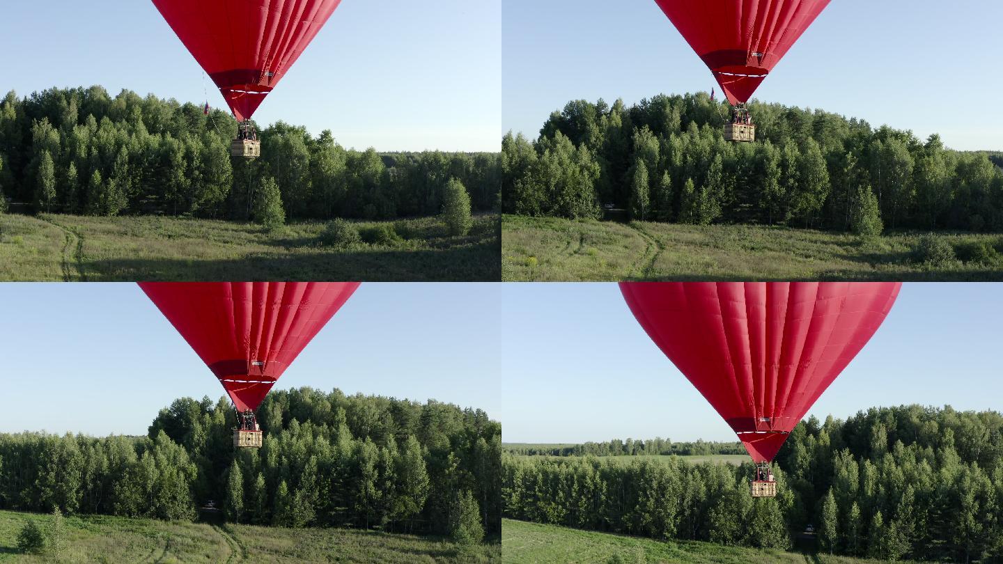 心脏形状的热气球在绿色田野和夏季森林上空飞行