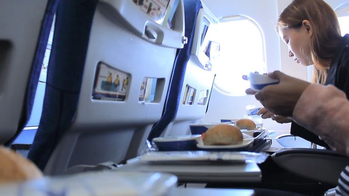 在飞机上吃午饭的乘客