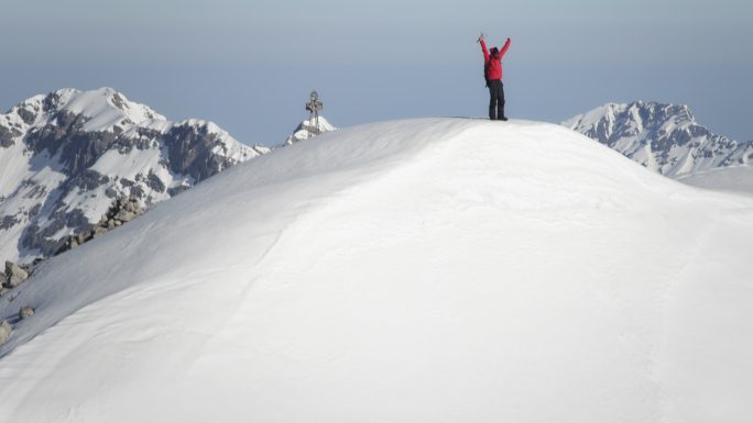 登山者在白雪覆盖的山峰上欣喜若狂