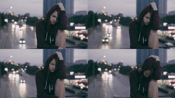 黄昏时独自坐在桥上沮丧的女孩。