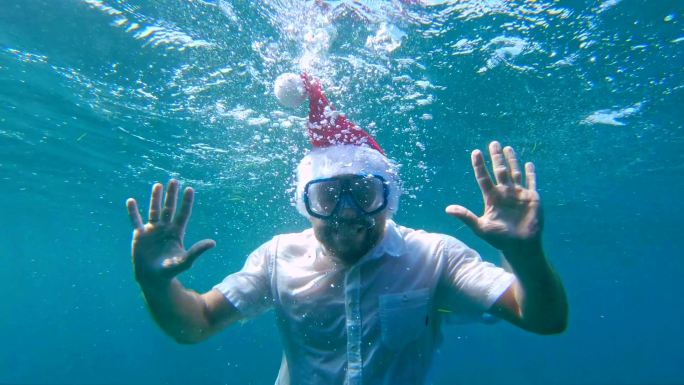 戴着圣诞帽和潜水面具的男人。