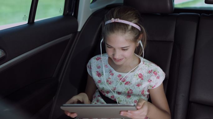 儿童在车内使用平板电脑玩在线游戏