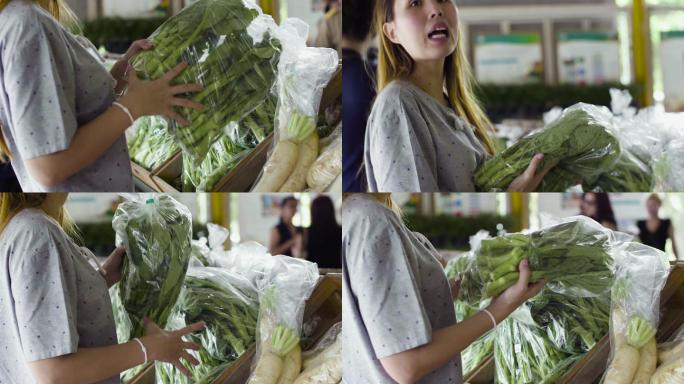 在新鲜市场买蔬菜的年轻女子