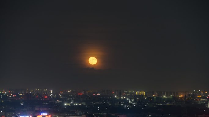 城市上空月亮穿云而出延时摄影素材