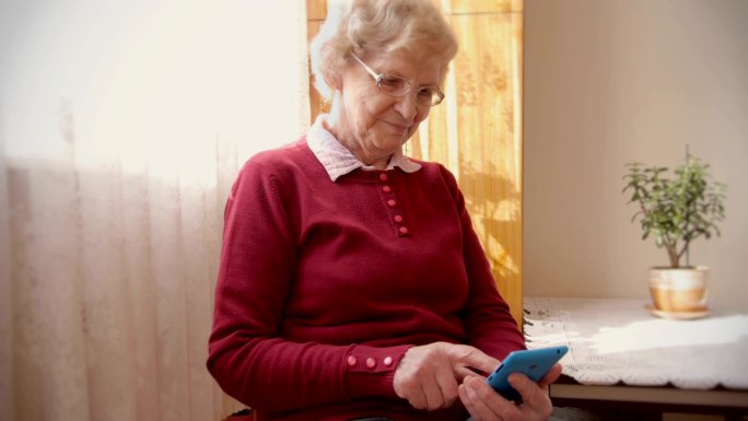 祖母轻敲智能手机上的按钮