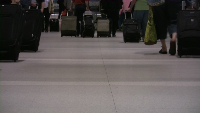 机场的旅客。低视角拖着行李箱出行旅途
