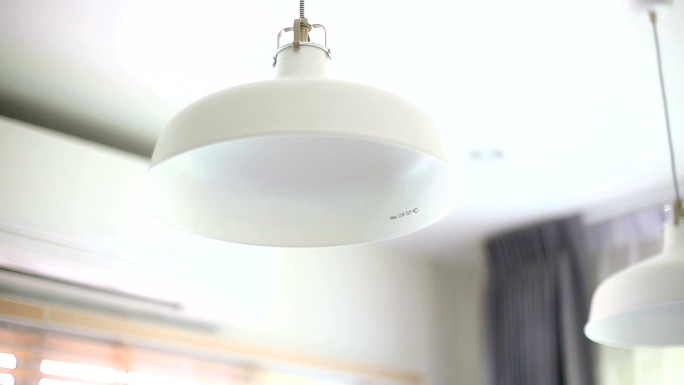 女性在家中将复古灯泡更换为LED灯。