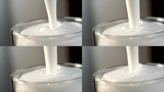 牛奶流落入装满泡沫牛奶的玻璃杯中