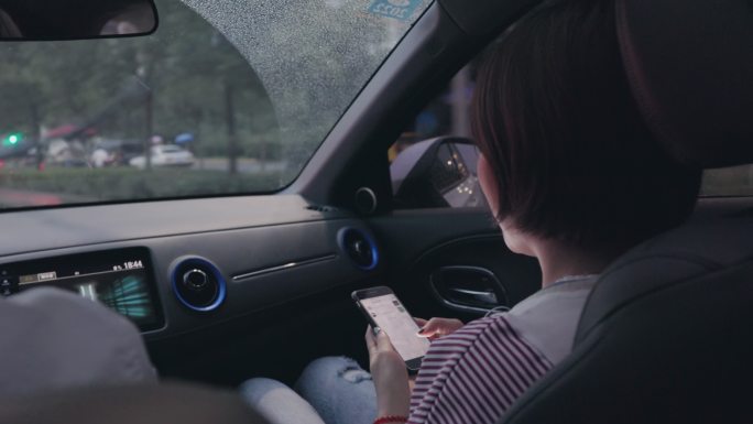 4K行驶中的汽车副驾上的年轻女性玩手机