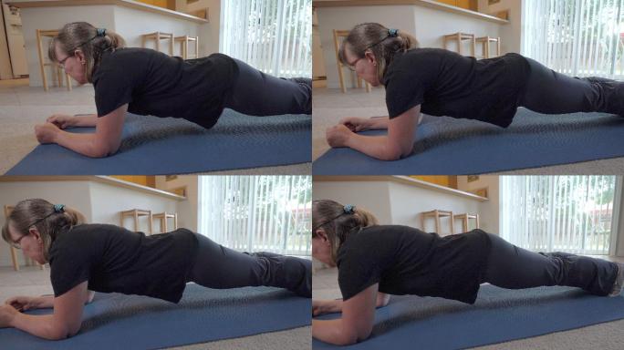 妇女爬在瑜伽垫上，在家里锻炼的视频