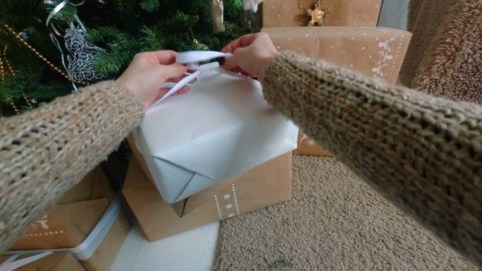 女人在圣诞礼品盒上缠丝带