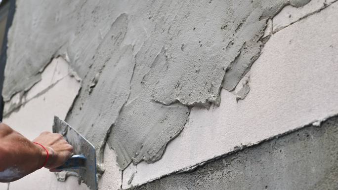 建筑工人把建筑胶涂在墙上。