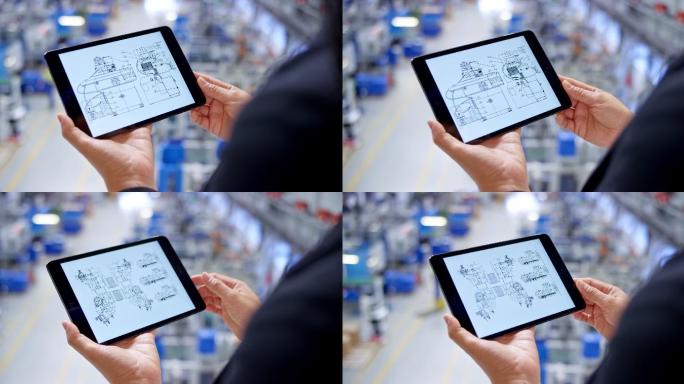 在工厂，女工程师手持平板电脑检查平面图
