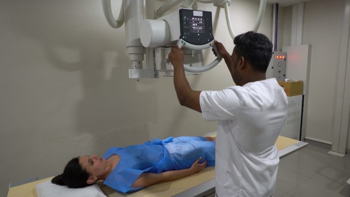 技术人员为躺下的患者准备x光机