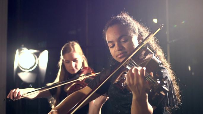 两个少女在音乐会上演奏小提琴
