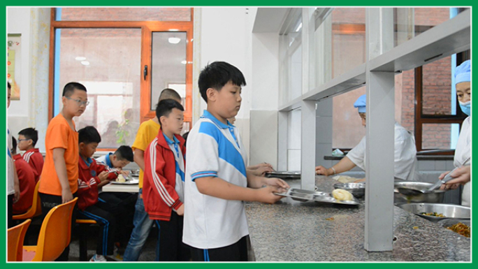 小学生在食堂排队打菜打饭