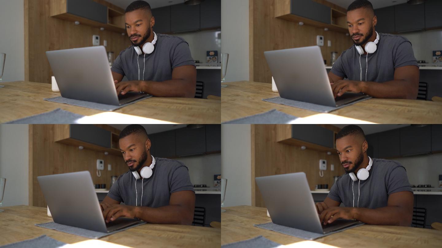 一个黑人男子专注的用笔记本电脑工作