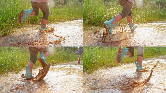 一个穿着雨靴的小孩在泥泞的水坑里奔跑