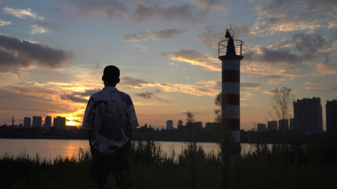 灯塔夕阳逆光剪影男人