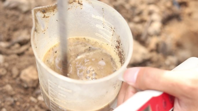 土壤检测化验将土壤放到烧杯里搅拌泥水